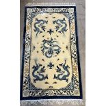 A Chinese rug with a cream ground decorated with dragons,