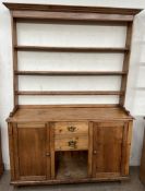 A Victorian pine dresser the open rack with a moulded cornice and three shelves,