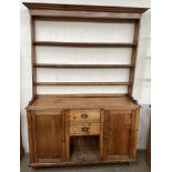 A Victorian pine dresser the open rack with a moulded cornice and three shelves,