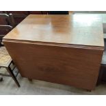 A 19th century mahogany gateleg dining table with a rectangular top and drop flaps on square legs