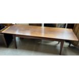 A mid 20th century teak coffee table with a rectangular top on tapering legs,