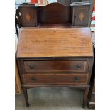 An Edwardian mahogany bureau with a raised superstructure and cupboards above a sloping fall
