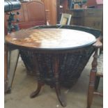 A Victorian walnut games table with an oval top on four column supports and splayed legs