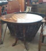 A Victorian walnut games table with an oval top on four column supports and splayed legs