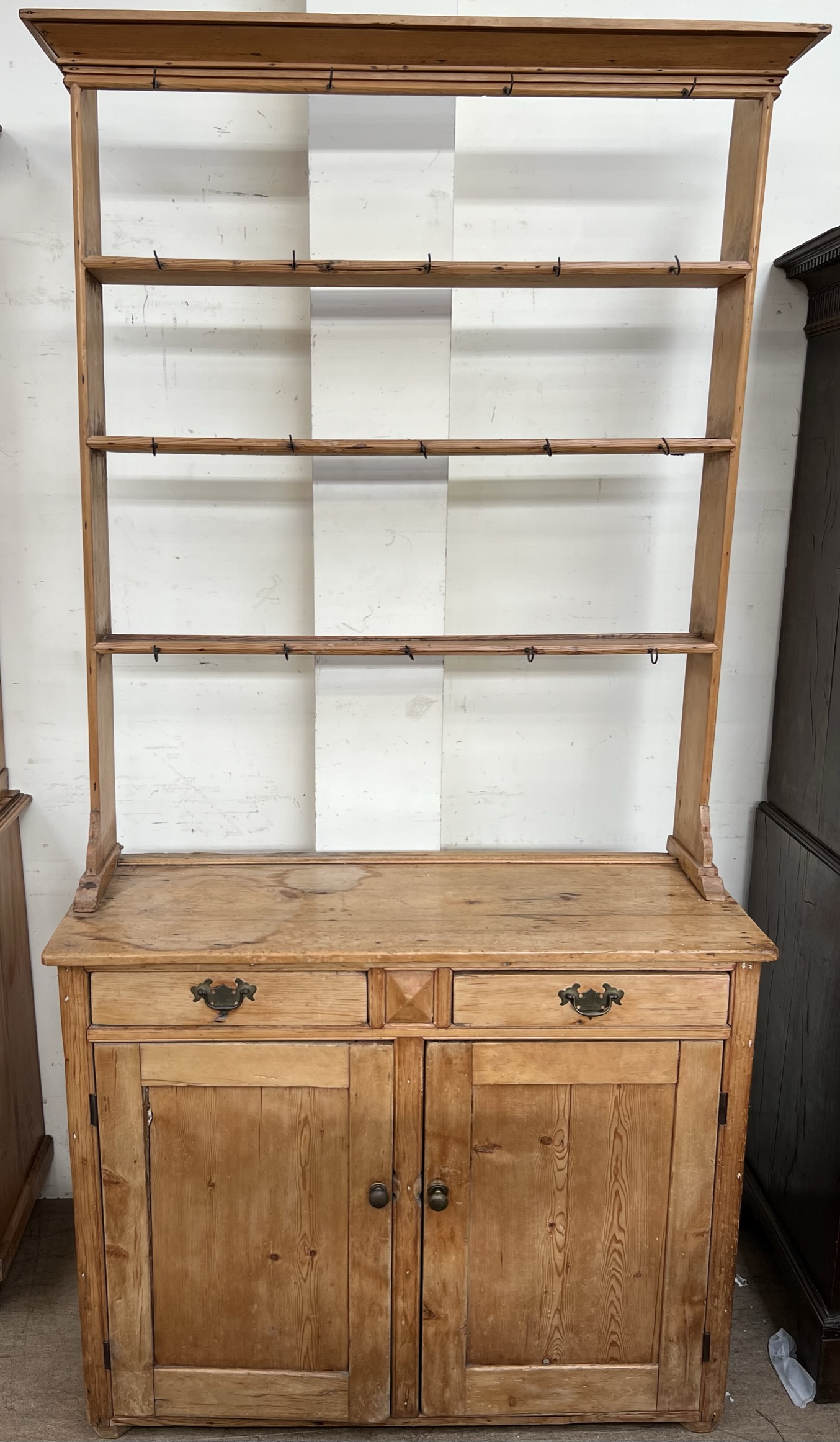 A Victorian pine dresser, the open rack with a moulded cornice above three shelves,