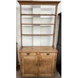 A Victorian pine dresser, the open rack with a moulded cornice above three shelves,