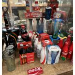 A collection of Coca Cola memorabilia including bottles, glasses,