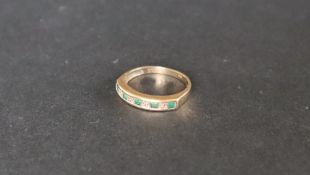 An emerald and diamond half eternity ring,