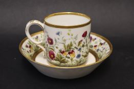 A 19th century French porcelain coffee can and saucer decorated with flowers and leaves to a thick