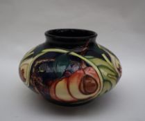 A Moorcroft pottery squat circular vase, decorated in the "Queen's Choice" pattern, dated 2000,