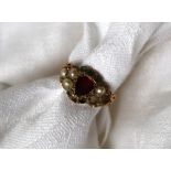 A Victorian dress ring set with a central heart shaped garnet,