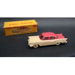 A Dinky Toys 180 Packard Clipper Sedan with windows having a cerise upper body,