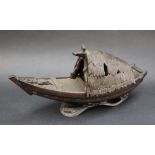 A bronze model of a boat with a removable canopy, seated upon waves,