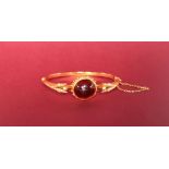 A garnet and seed pearl hinged bangle,