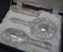 An Elizabeth II silver four piece dressing table set comprising a hand mirror, hair brush,