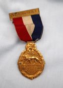 An Official's badge for the British Empire Games, 1934, with a gilt bar, red white and blue ribbon,