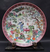 A Chinese Famille Rose porcelain charger decorated with numerous figures in a landscape,