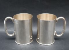 A pair of silver tankards, of tapering form with a C shaped handle, Sheffield, 1935,