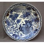 A large Oriental porcelain bowl decorated with a bird of paradise, flowers and leaves,