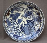 A large Oriental porcelain bowl decorated with a bird of paradise, flowers and leaves,