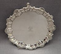 A George II silver waiter with a circular shell and scroll border,
