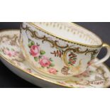 A Swansea porcelain tea cup and saucer painted with roses in a gilt garland border, 9.