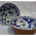 A pair of Chinese porcelain bowls with brown exterior, the inside decorated with fish and leaves,