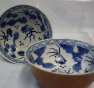 A pair of Chinese porcelain bowls with brown exterior, the inside decorated with fish and leaves,