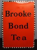 An orange and black enamel sign with a chequered border for "Brooke Bond Tea",