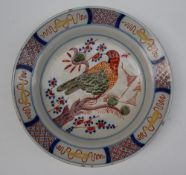 A Delft tin glazed earthenware charger polychrome decorated with a parrot in a tree the border