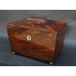 A Victorian rosewood sarcophagus tea caddy, with a reeded top on four brass ball feet,