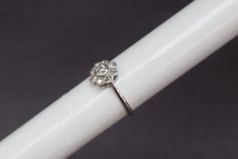 A diamond daisy cluster ring, set with a central old cut diamond,