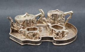 A Chinese white metal miniature five piece tea set comprising a hot water jug, teapot, cream jug,