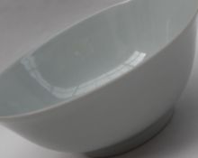 A Chinese porcelain bowl with a flared rim the white glazed body decorated with five toed dragons
