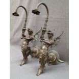 A pair of bronze wall mounted gas lights in the form of a winged mermaid,