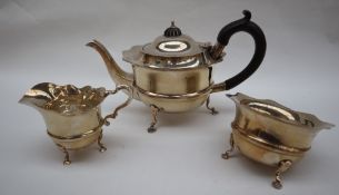 An Edward VII silver three piece tea set, with a flared rim and ring turned body on three legs,