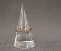 A diamond cluster ring, set with seven old cut diamonds to a daisy formation,