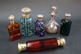 A silver topped and green glass scent bottle together with three other white metal topped scent