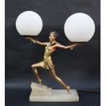 An Art Deco style table lamp with a gilt decorated maiden holding aloft a pair of white globe