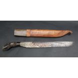 An Indonesian dagger with a carved and white metal mounted handle,