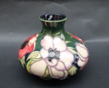 A Moorcroft pottery "Anemone" pattern vase of squat form with a green ground,