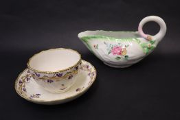 An 18th century Derby leaf sauce boat, decorated with flowers and leaves with a scrolling handle,