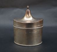 A George V silver tea canister of pointed oval form, the domed cover with a ball finial,