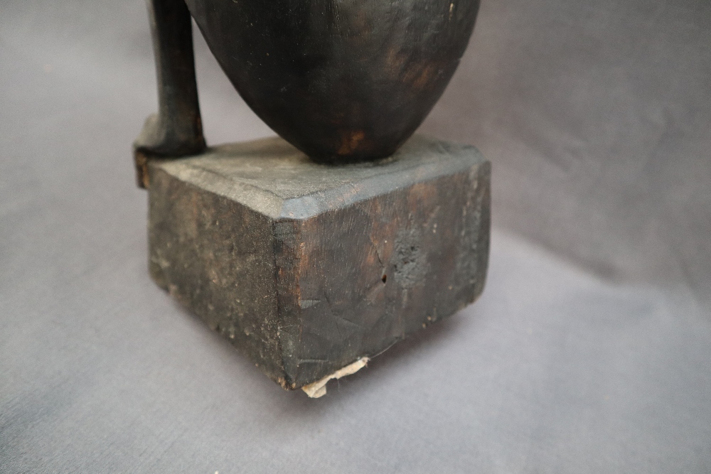 An African carving of a seated figure with his head resting on his right hand on a square plinth, - Image 7 of 8