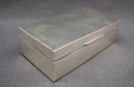 A George VI silver cigarette box of rectangular form with engine turned decoration and a vacant