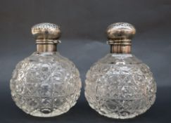 A pair of Edward VII silver topped and cut glass globe shaped scent bottles with dimpled tops,