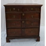 An 18th century oak chest with a rectangular top above two short and three long drawers on bracket