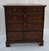 An 18th century oak chest with a rectangular top above two short and three long drawers on bracket