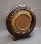 An Ekco all electric radio receiver Type A22 with a circular bakelite casing, and knobs,