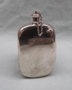 A small George IV silver hip flask of shaped oval form, the screw down lid secured by a chain,